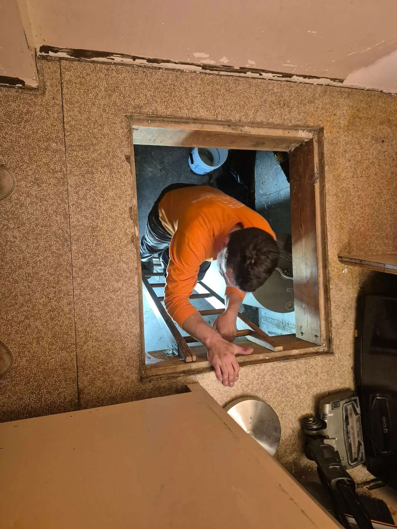 Howe Plumbing technician climbing through a crawlspace access