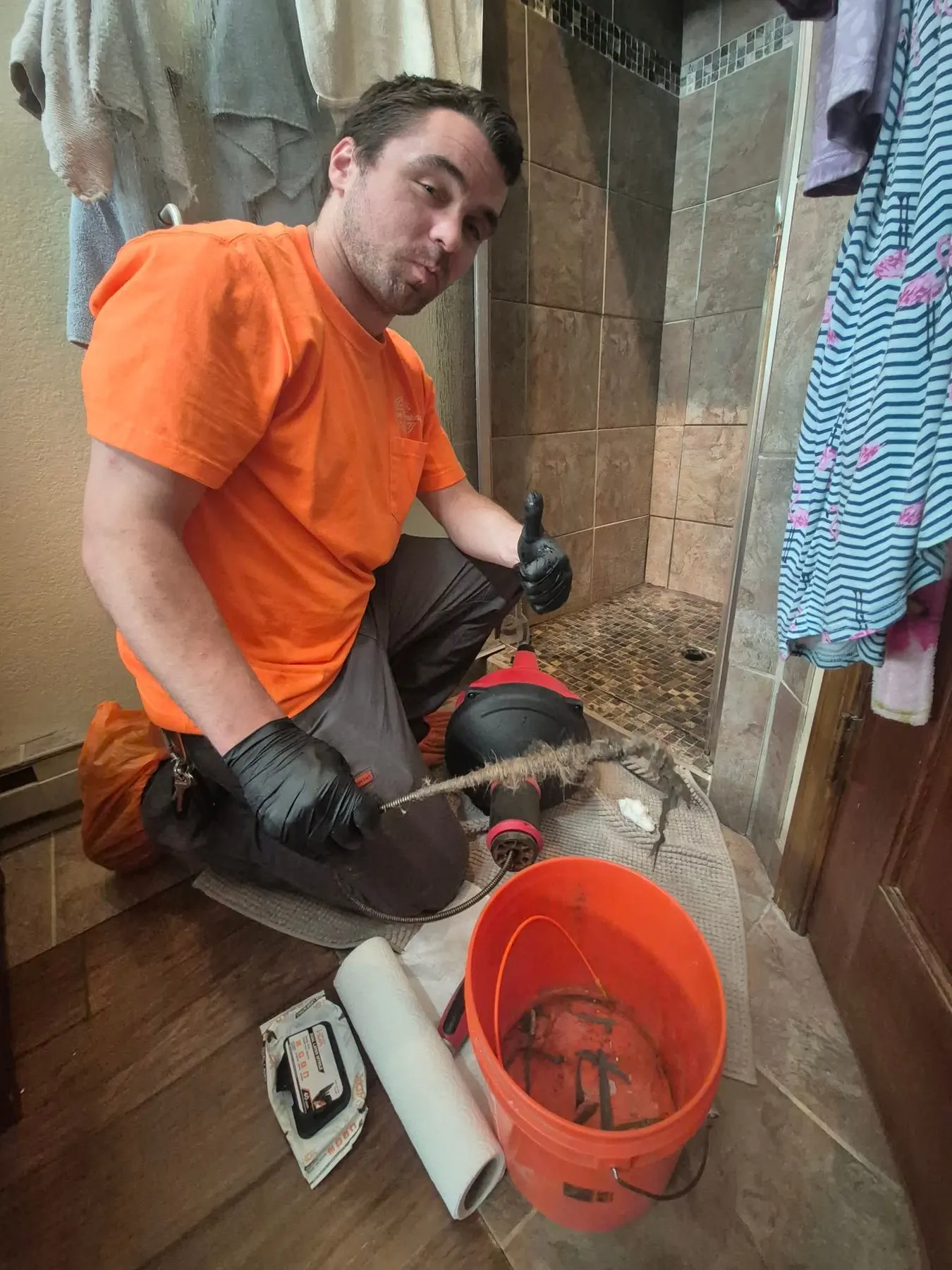 Howe Plumbing technician working on plumbing at floor level