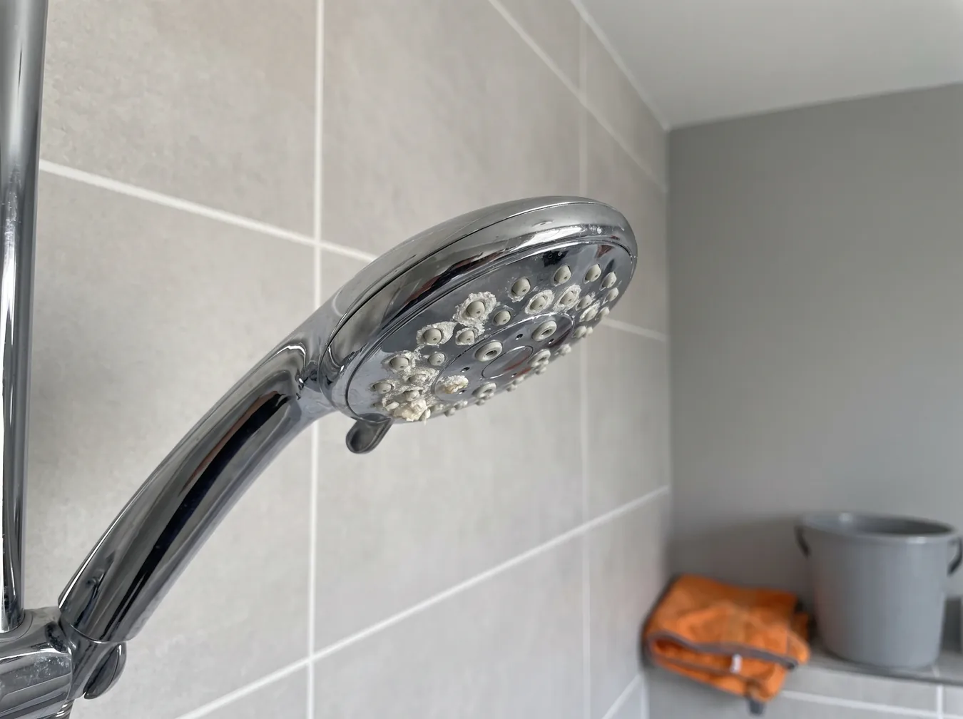 Showerhead clogged with white mineral scale