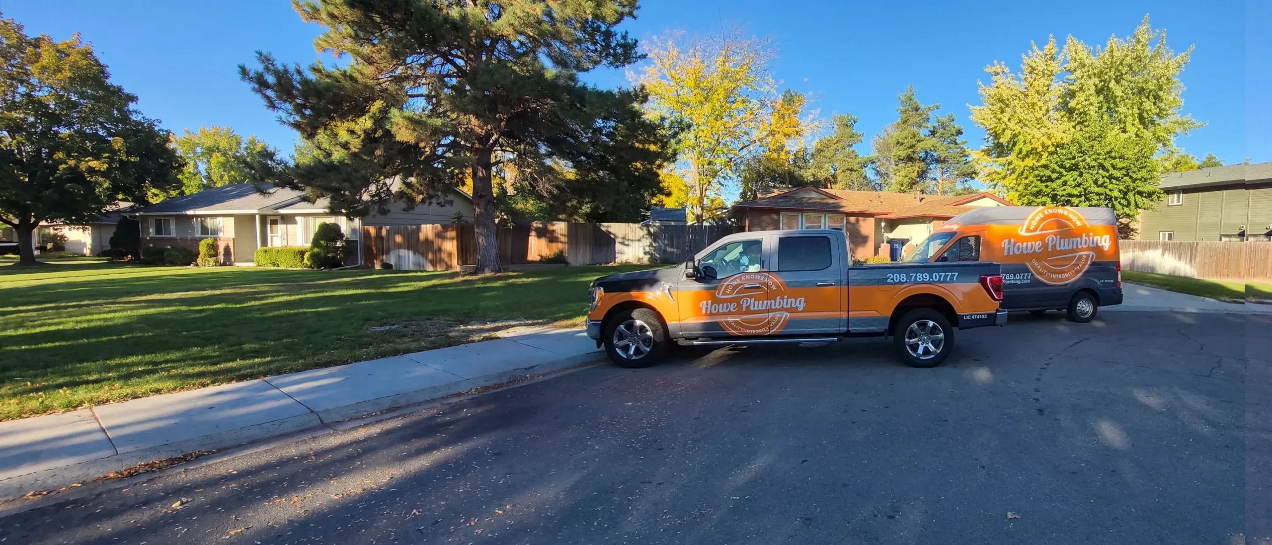 Howe Plumbing truck and van parked on a residential street in Boise