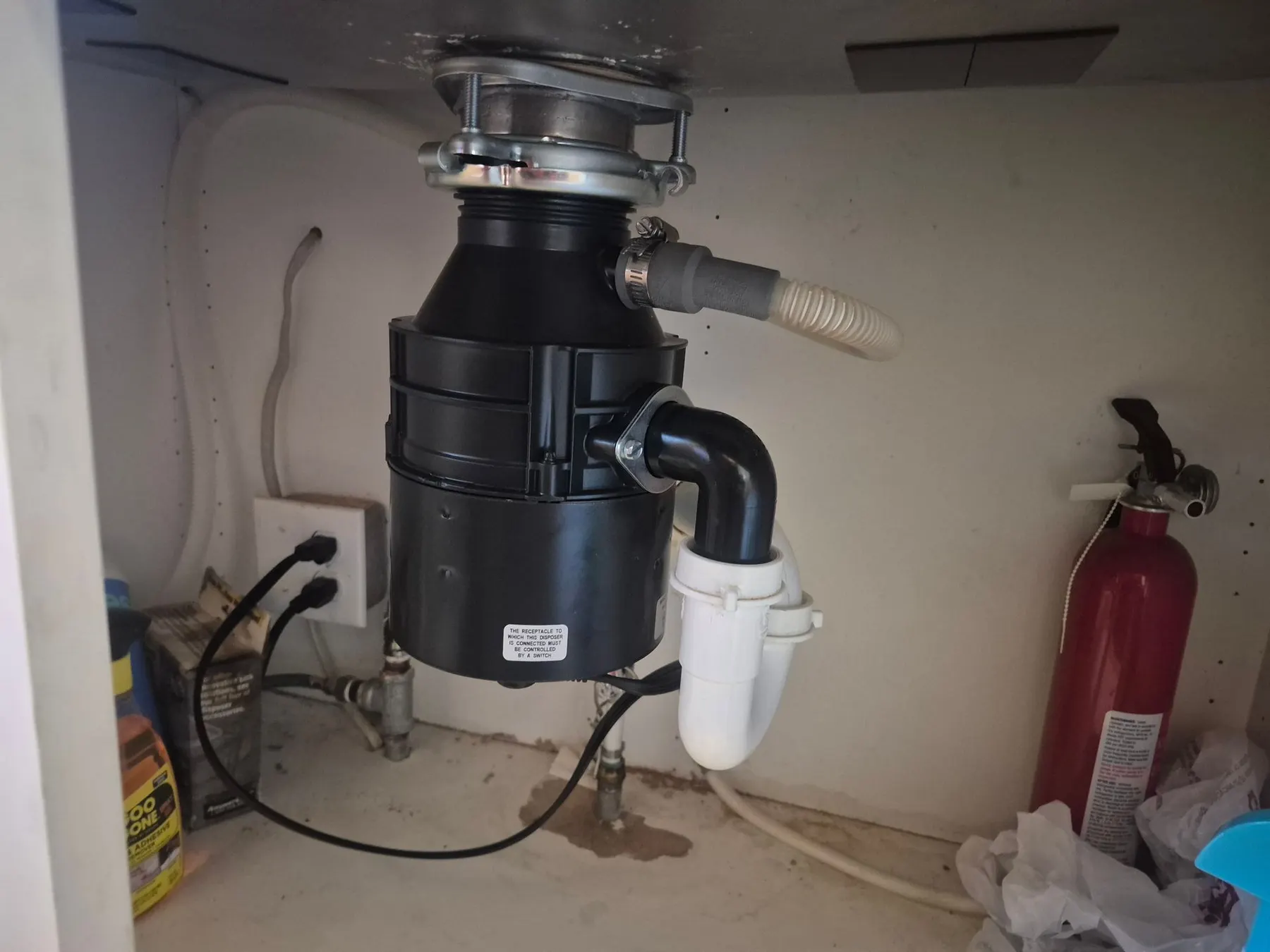Garbage disposal and drain plumbing under a kitchen sink