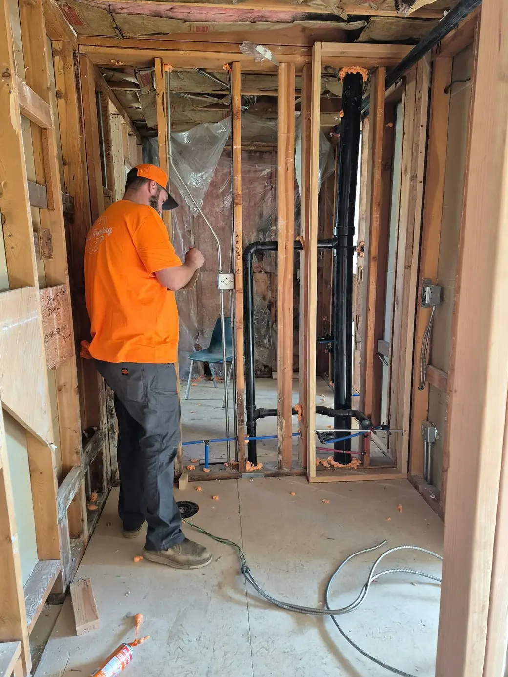 Howe Plumbing technician repiping a home with the walls open