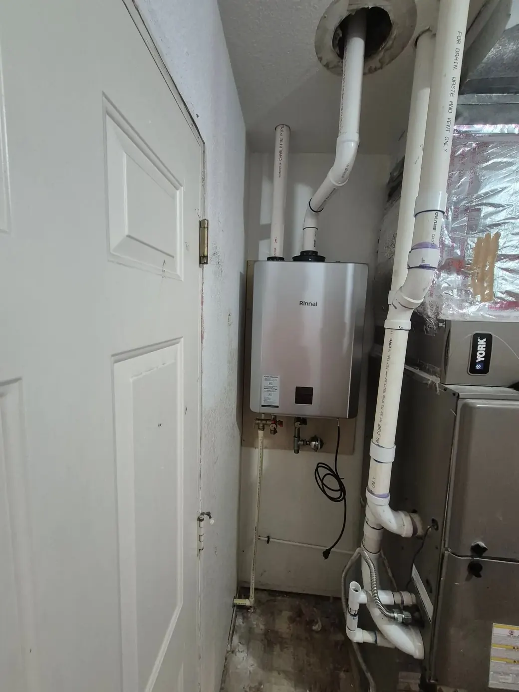 Rinnai tankless water heater installed on a utility room wall