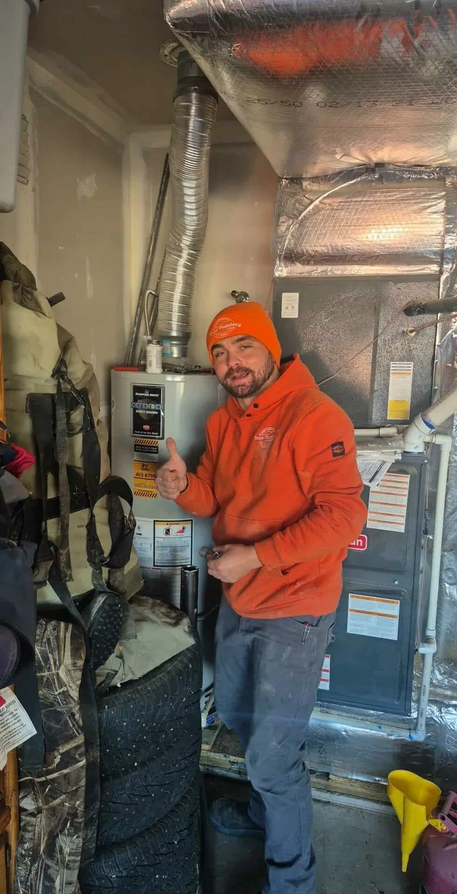 Howe Plumbing technician working in a home mechanical room